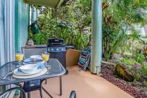 - une terrasse avec une table et un grill avec des boissons dans l'établissement Puamana 6B, à Princeville