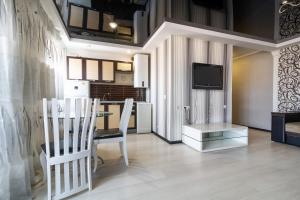 ein Wohnzimmer mit 2 Stühlen, einem Tisch und einem TV in der Unterkunft New apartment Lux in Most City area in Dnipro