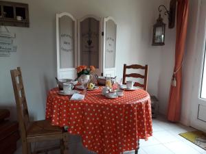 einem Tisch mit einem roten und weißen Tischtuch aus Polyka-Punkten in der Unterkunft le jardin de Camille in Tailleville