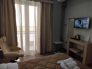 a hotel room with a bed and a tv and a window at City Point Chios in Chios