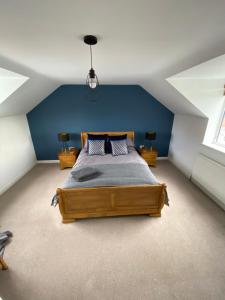 a bedroom with a large bed with a blue wall at Comfortable modern 1bed house 5 mins from centre in Lincoln