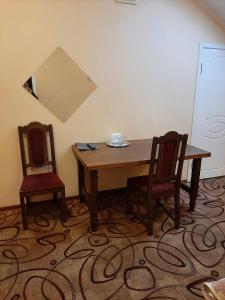 1 mesa y 2 sillas en una habitación en Metropol, en Rostov-on-Don