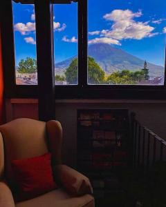 a chair in a room with a view of a mountain at Hotel Posada San Pedro in Antigua Guatemala +27 photos