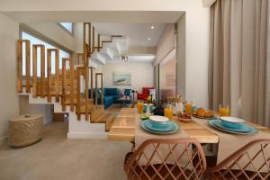 a dining room with a table and a staircase at Tessera Boutique Hotel & Villas Collection in Gouvia