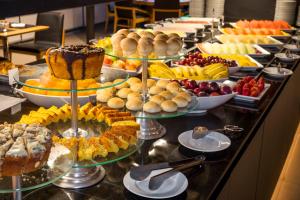 a buffet with many different types of cakes and fruit at Brasil 21 Convention Affiliated by Meliá in Brasilia