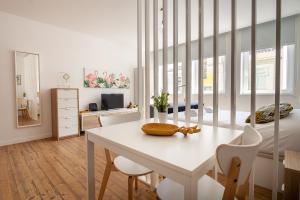 Habitación blanca con mesa, sillas y 1 dormitorio. en Carpe Diem by Home Sweet Home Aveiro, en Aveiro