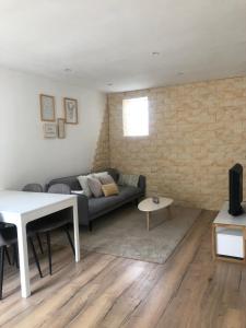 a living room with a couch and a brick wall at Maison Miss Manon in Béthune