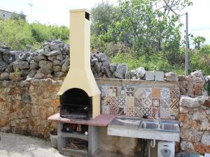 a pizza oven sitting on top of a stone wall at Holiday Home with Sea View in Vrbnik