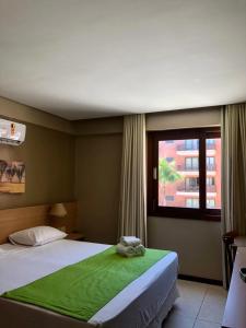 een slaapkamer met een groot bed en een raam bij Kariri Apartaments Sunset Beach in Cumbuco