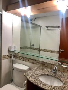 een badkamer met een toilet, een wastafel en een spiegel bij Kariri Apartaments Sunset Beach in Cumbuco