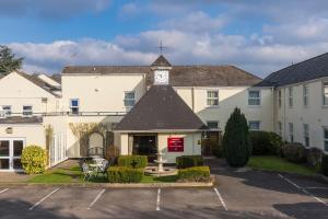 a large white building with a clock tower at Ramada by Wyndham Cheltenham in Cheltenham