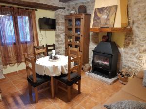 een eetkamer met een tafel en een open haard bij CA EFREN in Castellfort
