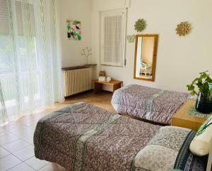 a hotel room with two beds and a mirror at Lakes&Hills Apartments in Erba