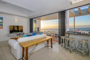 a living room with a white couch and a view of the ocean at Chakas Cove in Ballito