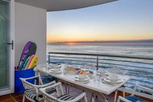 a table on a balcony with a view of the ocean at Chakas Cove in Ballito