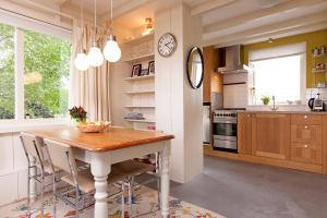 a kitchen with a table and a clock on a wall at Very nice cottage in Durgerdam, with private garden, free parking, pets allowed in Amsterdam