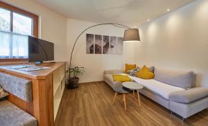 uma sala de estar com um sofá e uma televisão em Hochwart Apartment - Familienapartments em Saalbach-Hinterglemm