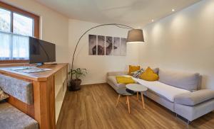 a living room with a couch and a tv at Hochwart Apartment - Familienapartments in Saalbach Hinterglemm