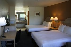 a hotel room with two beds and a desk at Lewis River Inn in Woodland