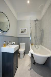 a bathroom with a sink and a tub and a toilet at Bramwood Guest House in Pickering +41 photos