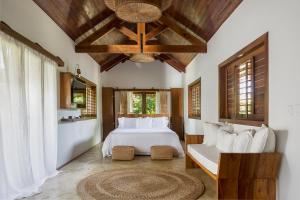 a bedroom with a large white bed and a chandelier at Villa Alegria - La Villa Group in Jericoacoara