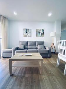 Sala de estar con sofá azul y mesa de centro en PRECIOSO APARTAMENTO EN EL TESORILLO en Almuñécar