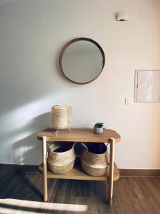 a table with baskets and a mirror on a wall at PRECIOSO APARTAMENTO EN EL TESORILLO in Almuñécar