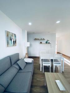 sala de estar con sofá, mesa y sillas en PRECIOSO APARTAMENTO EN EL TESORILLO, en Almuñécar