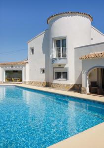 a villa with a swimming pool in front of a house at Casa Felizia in Els Poblets