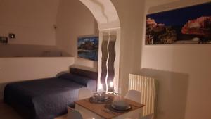 mały pokój z łóżkiem i stołem z tabelą sidx sidx w obiekcie Piazza grande w mieście Polignano a Mare