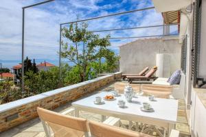 Un patio con una mesa y sillas en un balcón. en Villa Lemonia, en Glossa
