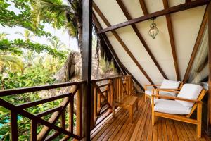 a living room filled with furniture and a balcony at Cayena Beach Villa in Guachaca
