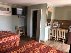 a hotel room with two beds and a kitchen with a microwave at Budget inn in Kingsville