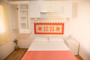 a small bedroom with a bed and white cabinets at Pousada Canto Verde in São Bento do Sapucaí