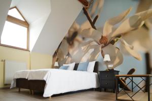 a bedroom with a bed with a flower mural on the wall at Timėjas in Ringaudai