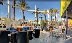 a patio with chairs and tables and palm trees at Bposhtels Las Vegas in Las Vegas