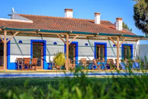 una casa con puertas azules, mesas y sillas en The New Laziness, en São Luis