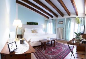 una camera con letto bianco, tavolo e sidro. di Il Bagattino a Ferrara