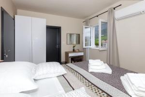Vitality Villa Mariante - free kajaks, sauna في Komolac: غرفة نوم بسرير ومخدات بيضاء ونافذة