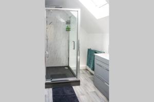a shower with a glass door in a bathroom at Walking distance to hospital and town with free off-road parking in Bury Saint Edmunds +11 photos