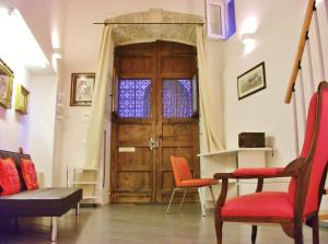 a living room with a wooden door and two chairs at Residenze Palazzo Pes in Cagliari