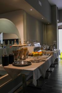 a long table with plates and bowls of fruit on it at Hotel San Nicola in Altamura