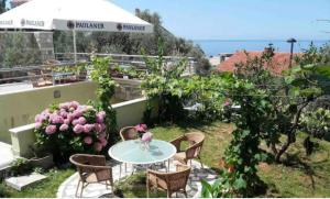 eine Terrasse mit einem Tisch, Stühlen und Blumen in der Unterkunft BMV room with east island view in Sveti Stefan