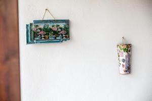 a wall with a picture of flowers in a shelf at Hotel Electra in Tolo