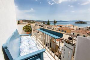 a balcony with a blue bench and a view of the water at Hotel Electra in Tolo