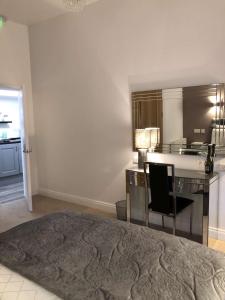 a bedroom with a desk with a chair and a kitchen at Atlantic Lodge, Main Street Ardara in Ardara