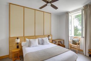 a bedroom with a bed and a ceiling fan at Le logis de Valandraud in Saint-Émilion