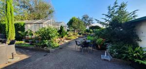 un jardín con mesa, sillas y plantas en B&B Knooppunt70 en Arcen