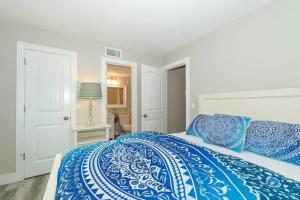a bedroom with a bed with blue and white sheets at Siesta Key Village-Suite #3: A Block to the Beach! in Sarasota
