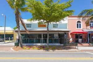 a building on the corner of a street with palm trees at Siesta Key Village-Suite #3: A Block to the Beach! in Sarasota